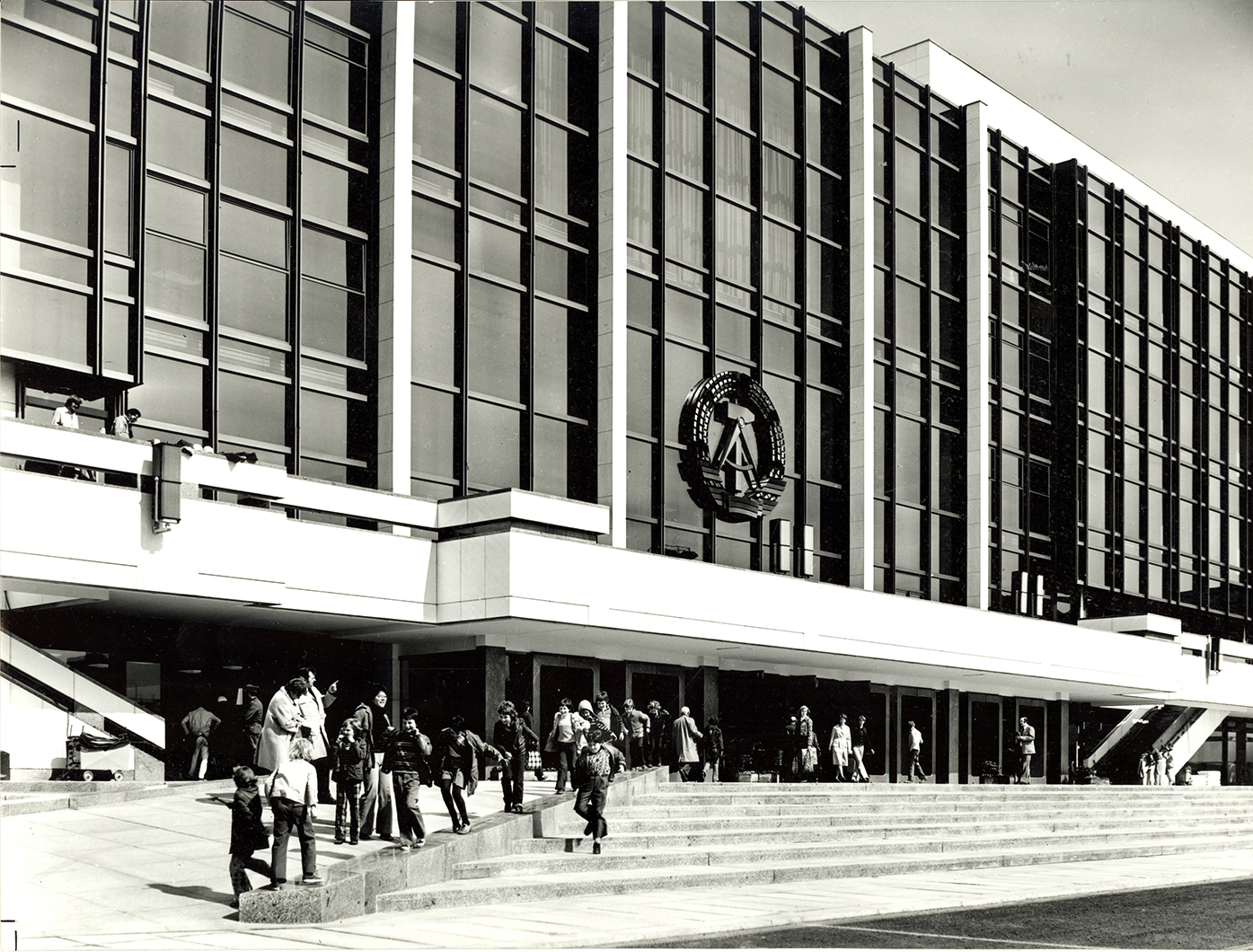 Der Palast der Republik im Jahr der Eröffnung 1976 von außen an der Haupteingangsseite mit dem Staatswappen der DDR (Aufnahme: Baum; Leibniz-Institut für Raumbezogene Sozialforschung, Wissenschaftliche Sammlungen, Bildarchiv D1_1_1_21-007)